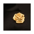 Close-up of A Rose Is a Rose golden rose bloom brooch on a black background, highlighting the sculptural rose petals, etched floral texture, and warm gold-tone finish.