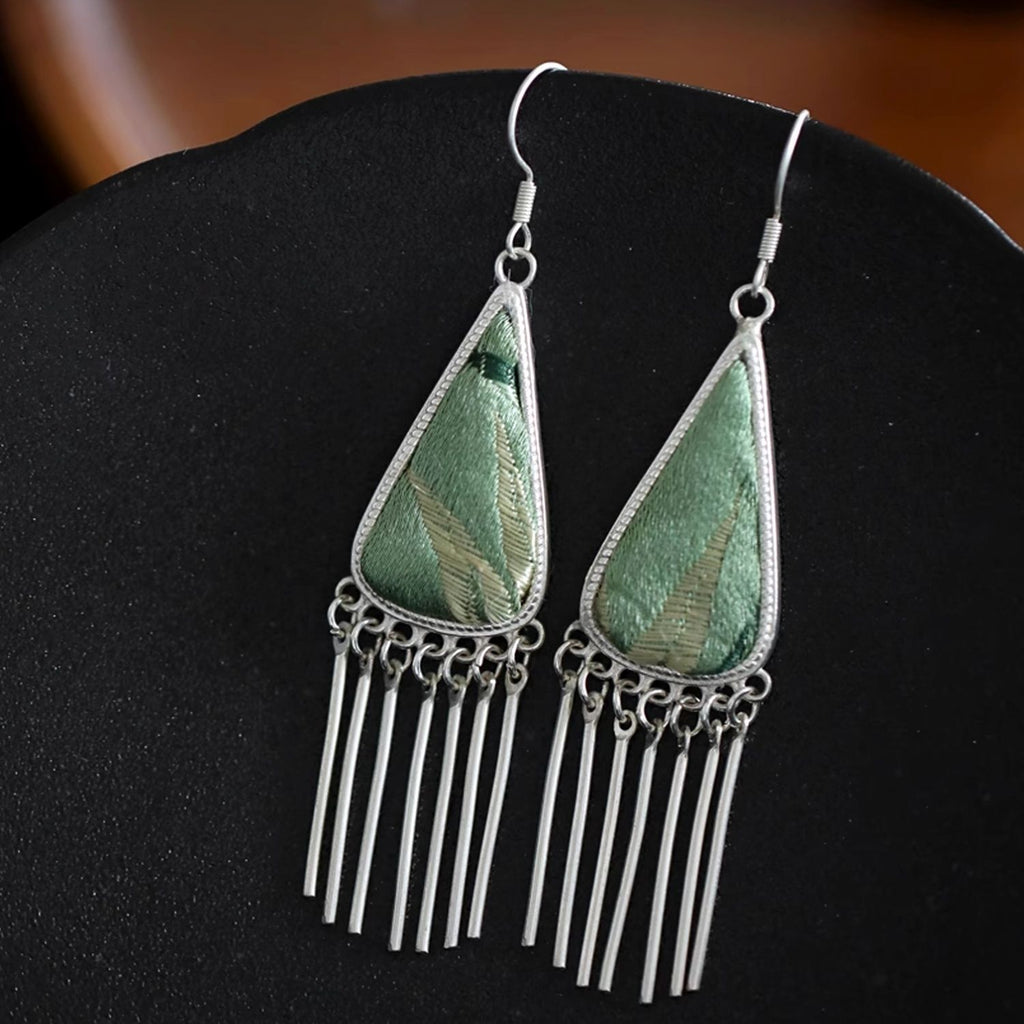 Bamboo green Song Brocade triangle fringe dangle earrings displayed upright, highlighting the woven silk texture and fluid fringe detail.