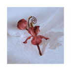 Angled view of Cloud Iris Chinese silk flower brooch, featuring dimensional Ronghua petals, soft rose tones, and delicate hand-shaped detail.