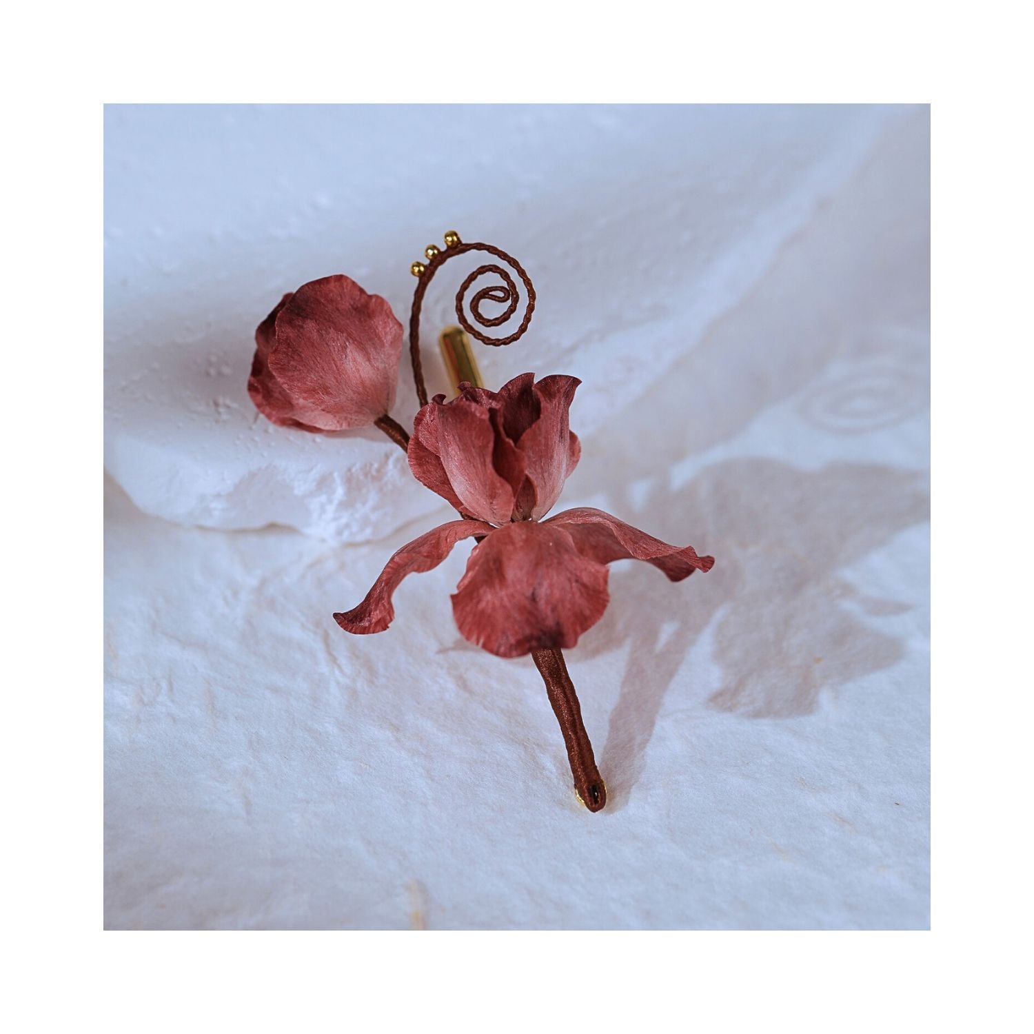 Angled view of Cloud Iris Chinese silk flower brooch, featuring dimensional Ronghua petals, soft rose tones, and delicate hand-shaped detail.
