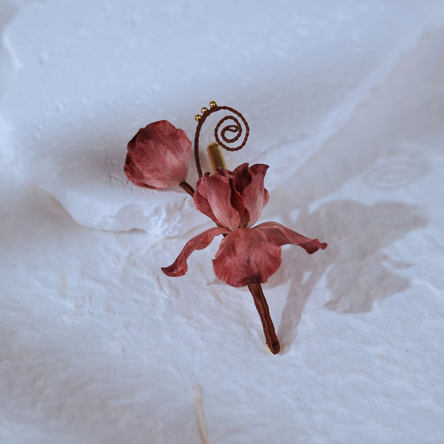 Close-up of Cloud Iris Ronghua silk flower brooch with hand-shaped mulberry silk petals and curled tendrils.