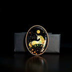 Custom mother-of-pearl inlay unicorn brooch with iridescent shell detail on a black display stand.