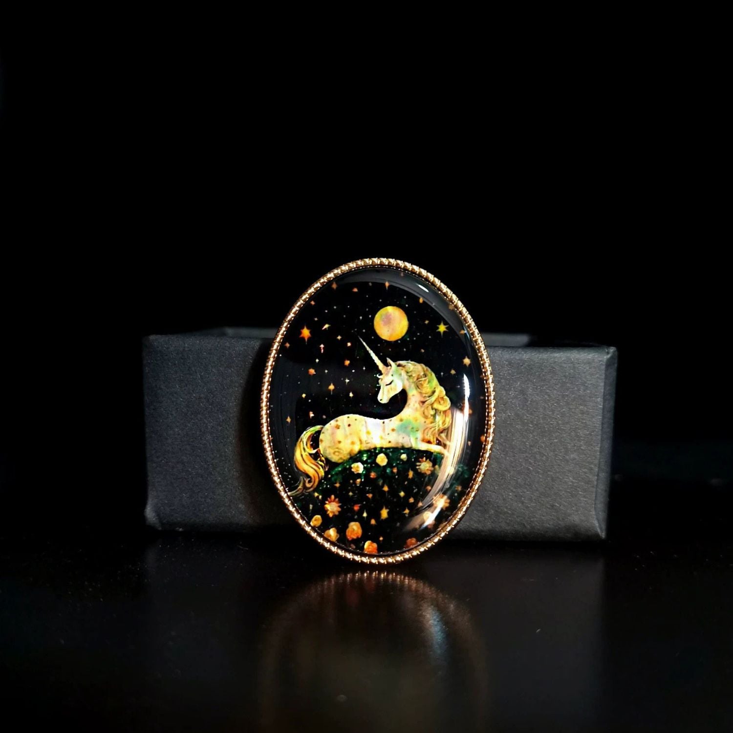 Custom mother-of-pearl inlay unicorn brooch with iridescent shell detail on a black display stand.