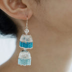 Close-up of blue gradient bugle bead drop earrings with a tiered lantern shape and delicate hand-strung beadwork.
