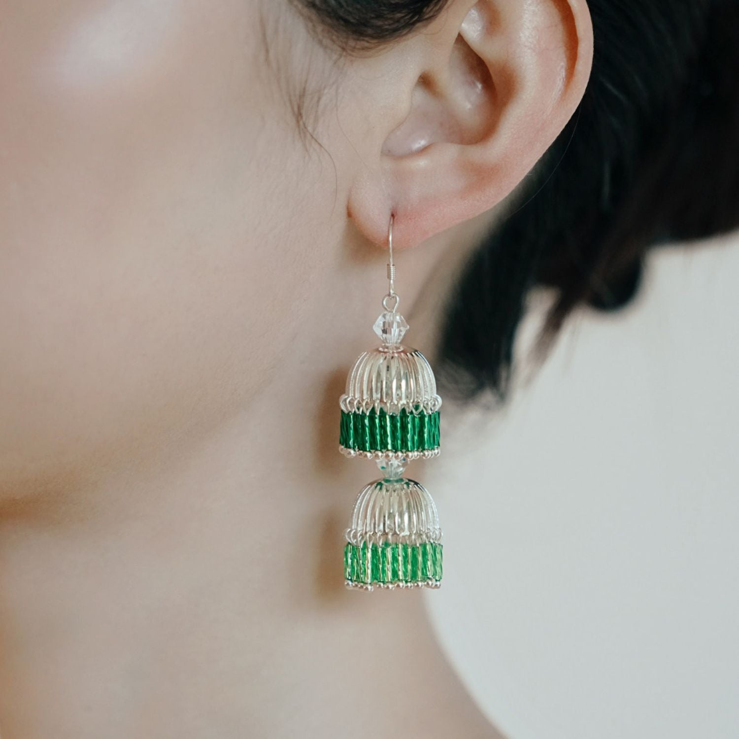 Close-up of green gradient bugle bead drop earrings with a double-lantern silhouette and hand-strung bead detail.