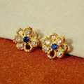 Eternal Blossom gold openwork flower stud earrings with sapphire-blue centre stone and cubic zirconia accents.