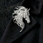 Silver-tone equestrian horse brooch with sculpted mane and vintage-inspired finish on black velvet.