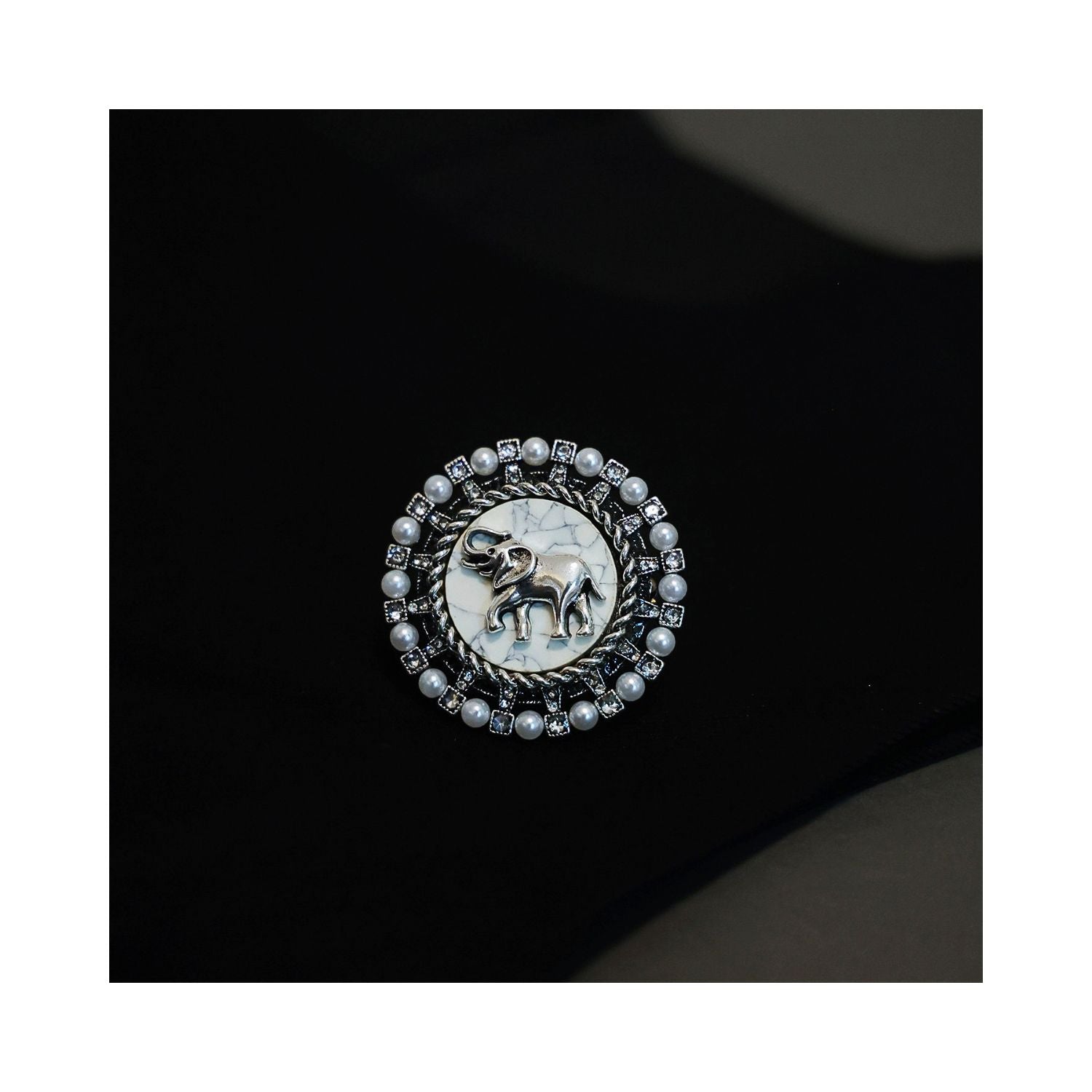 Jinherit Gentle Guardian elephant brooch pin shown on black fabric, highlighting vintage pearl detail, marbled ivory center, and meaningful animal brooch styling.