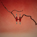 Jinherit Ancient Ember red agate and turquoise drop earrings displayed on a sculptural branch, featuring elongated red agate beads, turquoise accents, and antiqued silver-tone details.