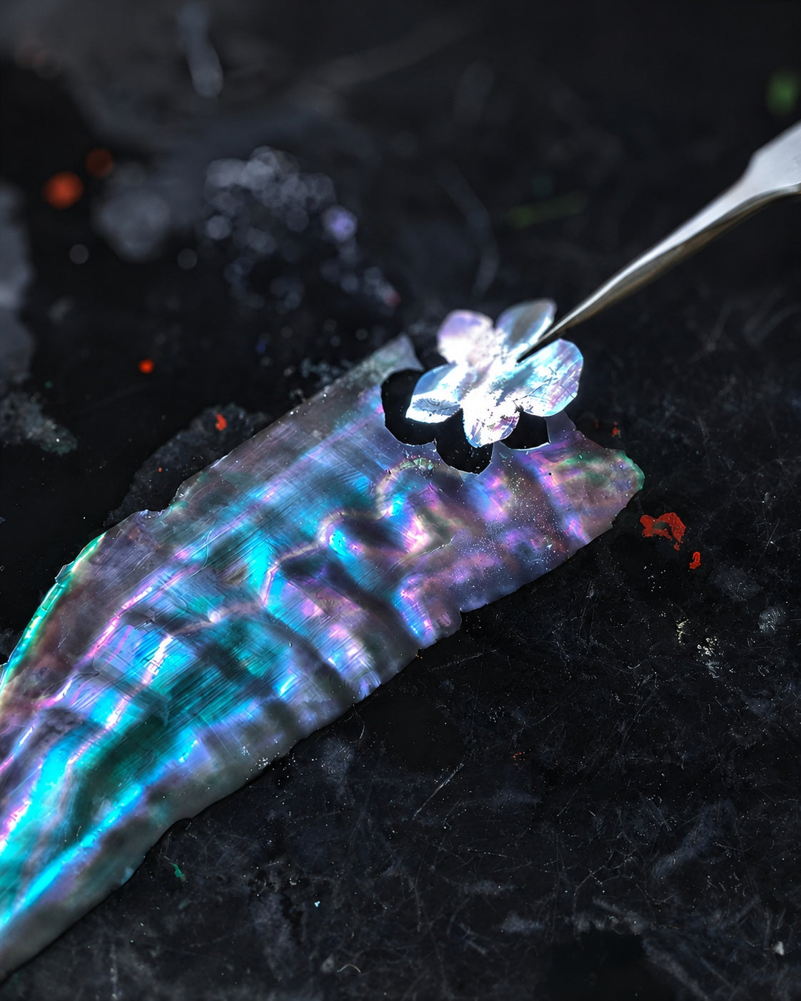 Iridescent mother-of-pearl inlay being shaped by hand, showcasing luminous artisan craftsmanship for Jinherit Artisan Heritage.