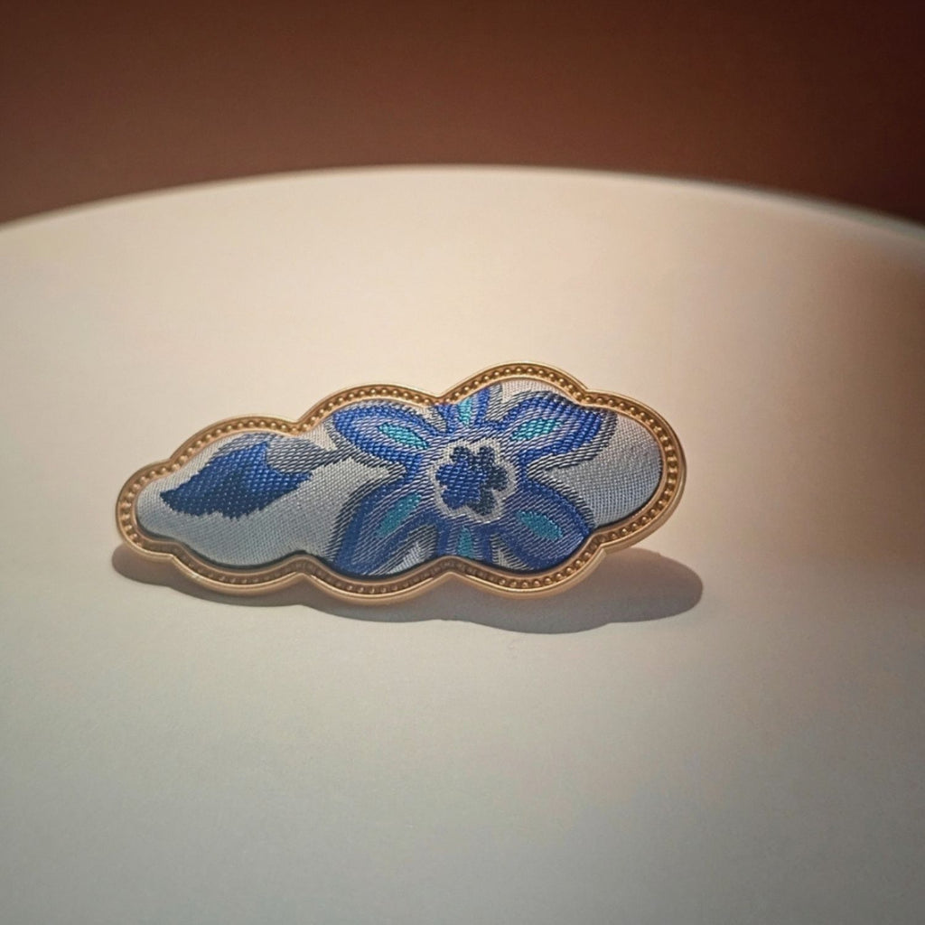 Jinherit Auspicious Cloud Song Brocade silk hair clip in Blue Floral, featuring blue floral brocade, a sculptural cloud silhouette, and a gold-tone flat alligator clip.
