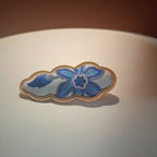 Jinherit Auspicious Cloud Song Brocade silk hair clip in Blue Floral, featuring blue floral brocade, a sculptural cloud silhouette, and a gold-tone flat alligator clip.