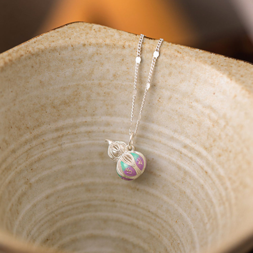 Jinherit Celestial Haze cloisonné enamel gourd necklace displayed on natural wood, highlighting the soft teal and lavender enamel, silver chain, and meaningful hulu motif.