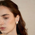 Jinherit Eternal Star brushed silver and vintage-gold studs worn by a model, highlighting the compact statement size, mixed-metal shimmer, and elegant everyday styling.
