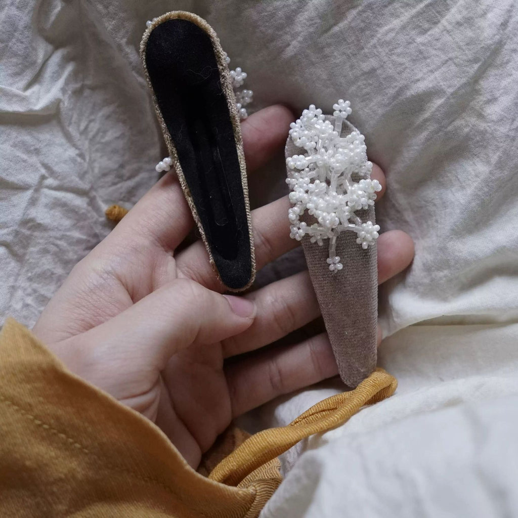 Jinherit Frosted Bloom beaded velvet Snap Clip shown in hand, highlighting the raised ivory bead clusters, velvet base, and handcrafted floral hair accessory detail.