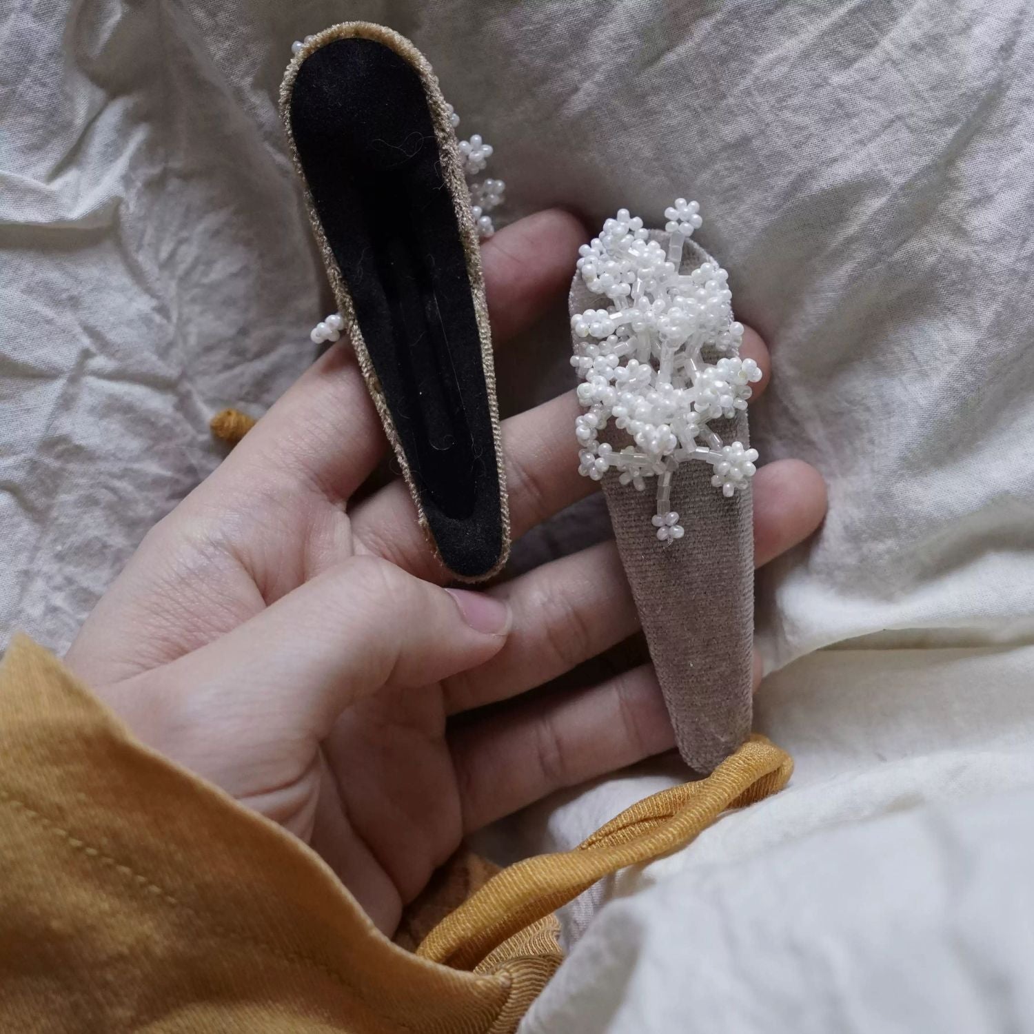 Jinherit Frosted Bloom beaded velvet Snap Clip shown in hand, highlighting the raised ivory bead clusters, velvet base, and handcrafted floral hair accessory detail.