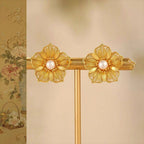 Jinherit Golden Bloom filigree pearl flower stud earrings front detail, showing layered gold-plated petals, lace-like metalwork, and luminous freshwater pearl centers.