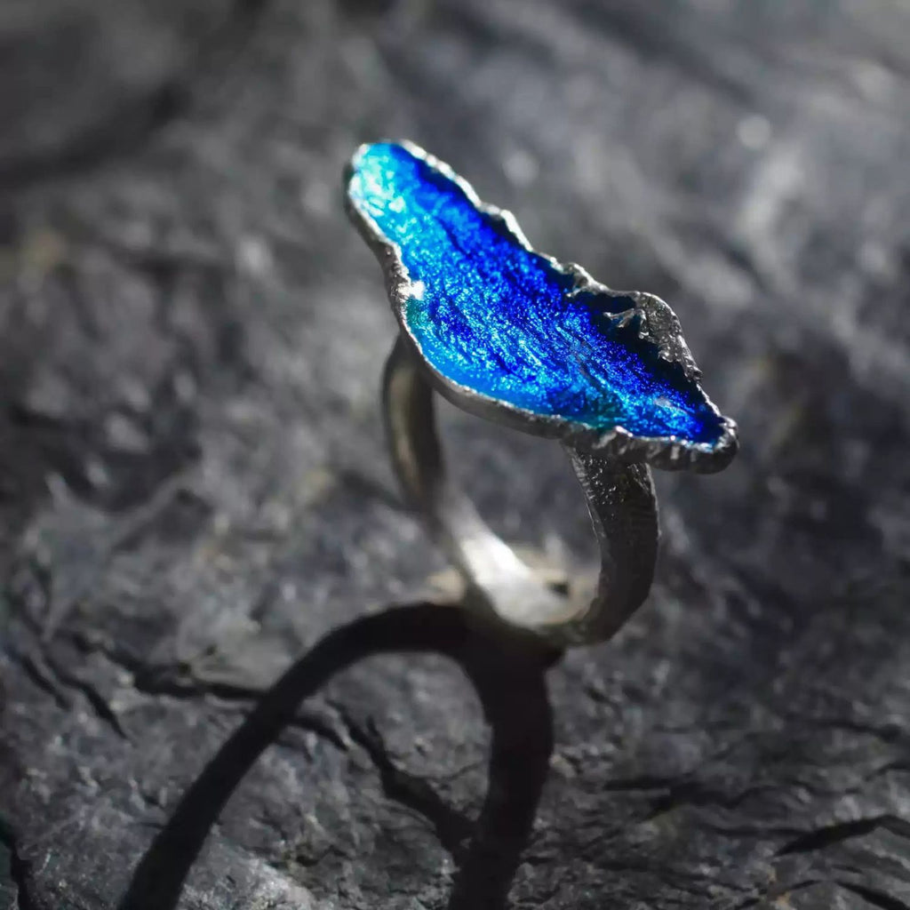Jinherit Into the Blue handcrafted enamel ring side detail, highlighting the raised blue enamel form, distressed sterling silver texture, and sculptural adjustable open band.