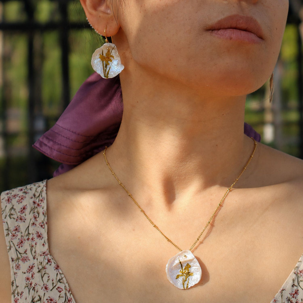 Jinherit Iris on Pearl freshwater pearl necklace worn by a model, highlighting the hand-painted floral pendant, collarbone-length styling, and botanical wearable art charm.