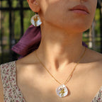 Jinherit Iris on Pearl freshwater pearl necklace worn by a model, highlighting the hand-painted floral pendant, collarbone-length styling, and botanical wearable art charm.