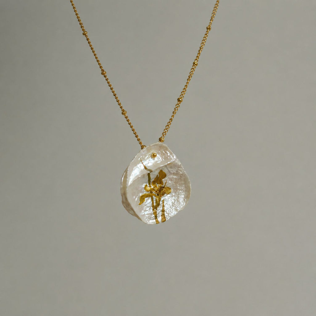 Jinherit Iris on Pearl necklace pendant detail, featuring a hand-painted iris flower on a natural petal-shaped baroque pearl with soft iridescent lustre.