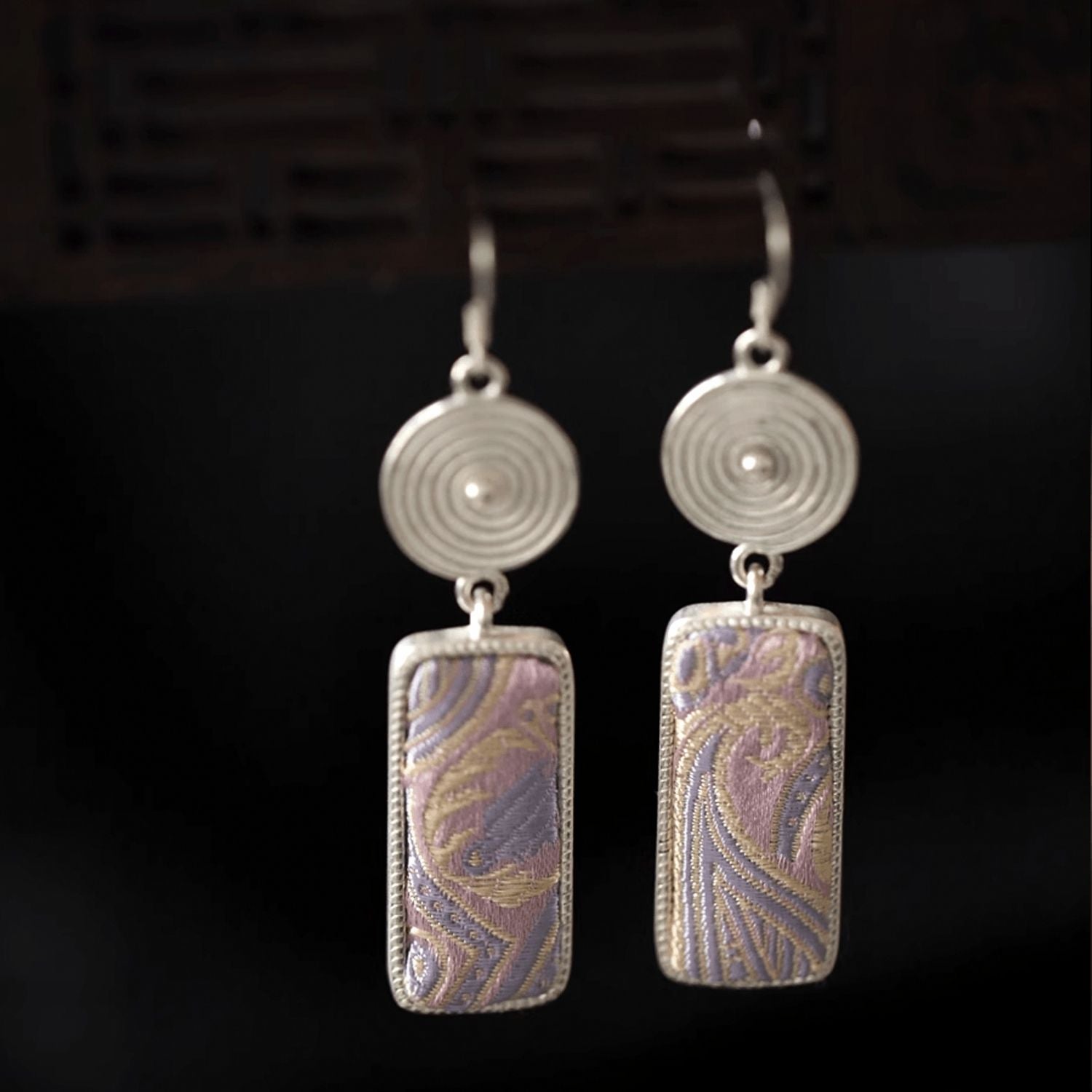 Jinherit Lilac Loom Song Brocade dangle earrings, featuring lilac and gold woven silk texture, silver-tone circular details, and a graceful rectangular drop silhouette.