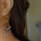 Jinherit Lustrous Tide iridescent pearl tassel drops worn by a model, showing the face-framing chandelier silhouette, pearl movement, and refined evening styling.