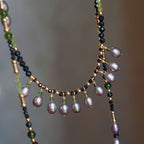 Jinherit Lustrous Tide pearl tassel wrap necklace, featuring iridescent freshwater pearls, black spinel beads, peridot accents, and 14K gold-filled details in a hand-strung layered design.