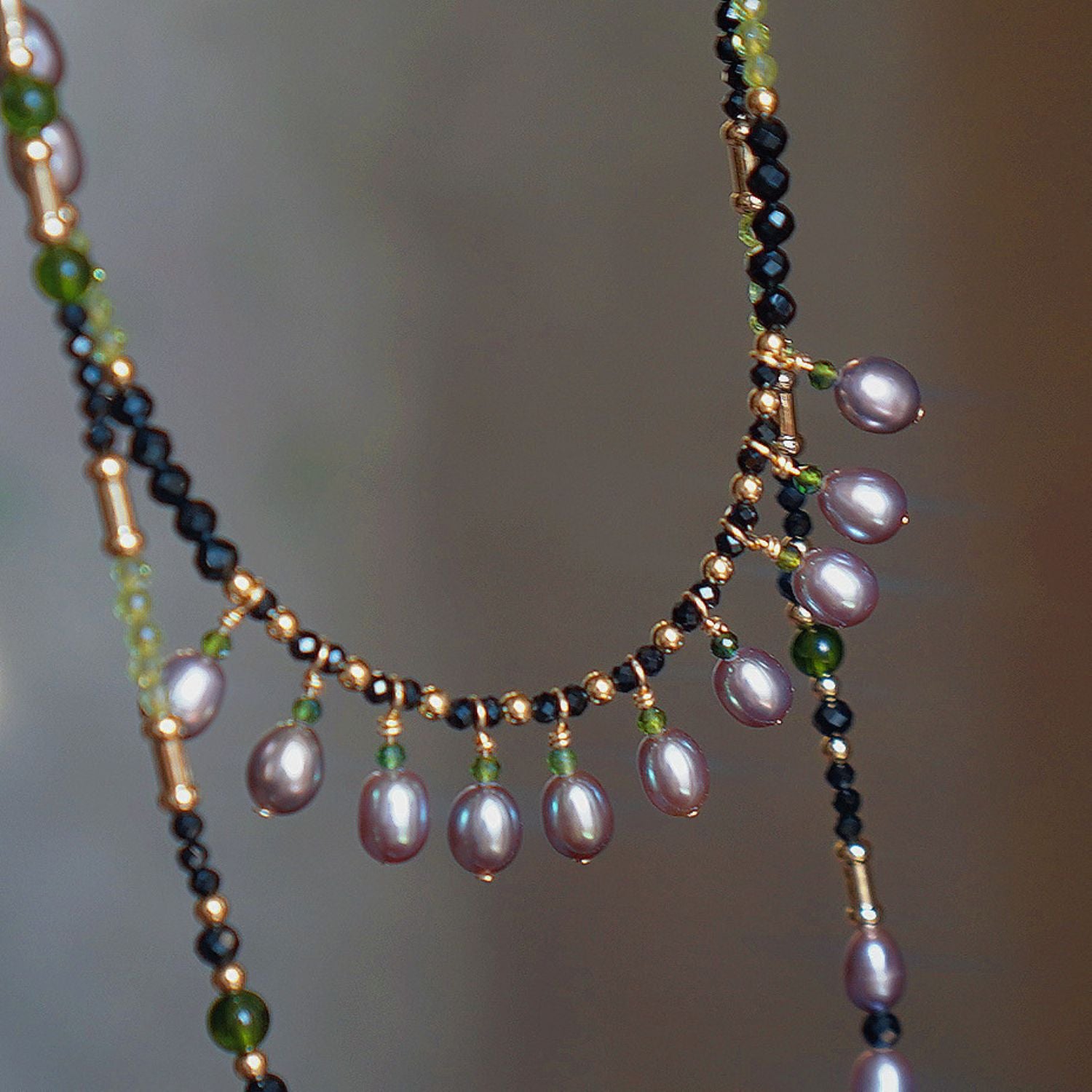 Jinherit Lustrous Tide pearl tassel wrap necklace, featuring iridescent freshwater pearls, black spinel beads, peridot accents, and 14K gold-filled details in a hand-strung layered design.
