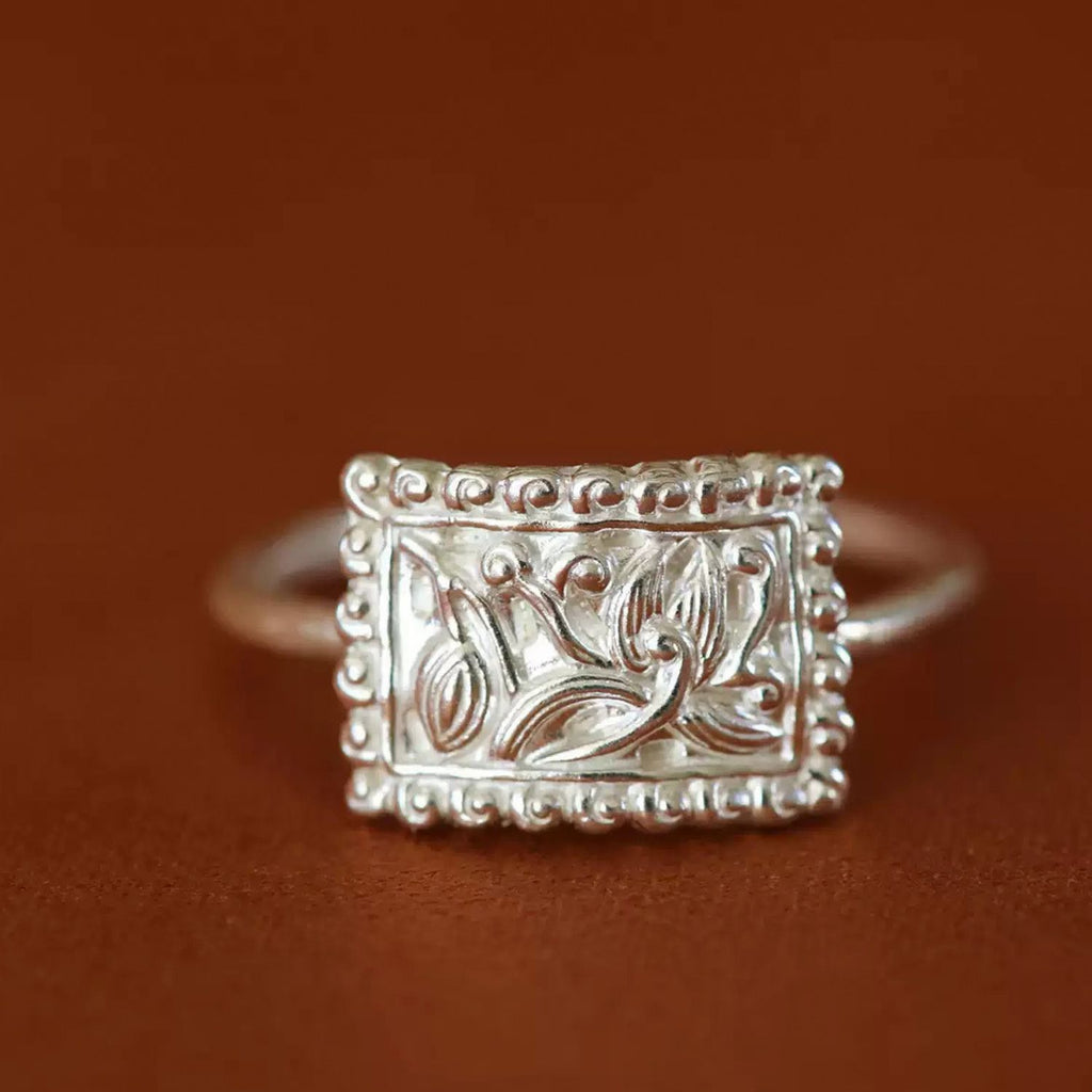 Jinherit Orchid Spirit engraved fine silver ring, featuring an S990 silver rectangular face, orchid floral motif, raised bead border, and Bai-inspired silverwork detail.