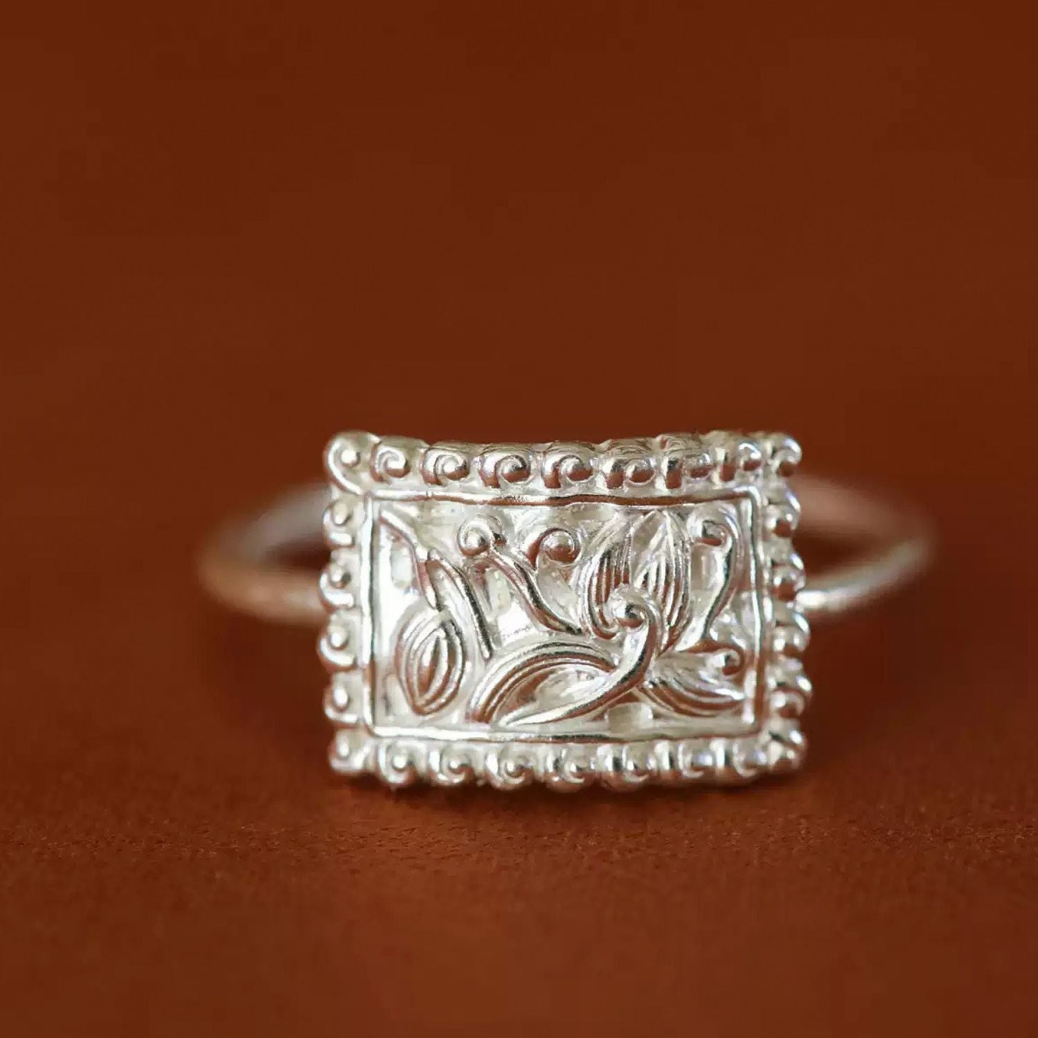 Jinherit Orchid Spirit engraved fine silver ring, featuring an S990 silver rectangular face, orchid floral motif, raised bead border, and Bai-inspired silverwork detail.