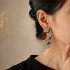 Jinherit Pine & Moon hand-painted Chinese lacquer drop earrings worn by a model, showing the bold oval shape, face-framing length, pine and moon landscape motif, and heritage-inspired styling.