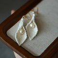 Jinherit Pure Calla beaded calla pearl drop earrings displayed in a jewelry box, featuring hand-beaded white seed beads, calla lily-inspired petals, and freshwater pearl drops.