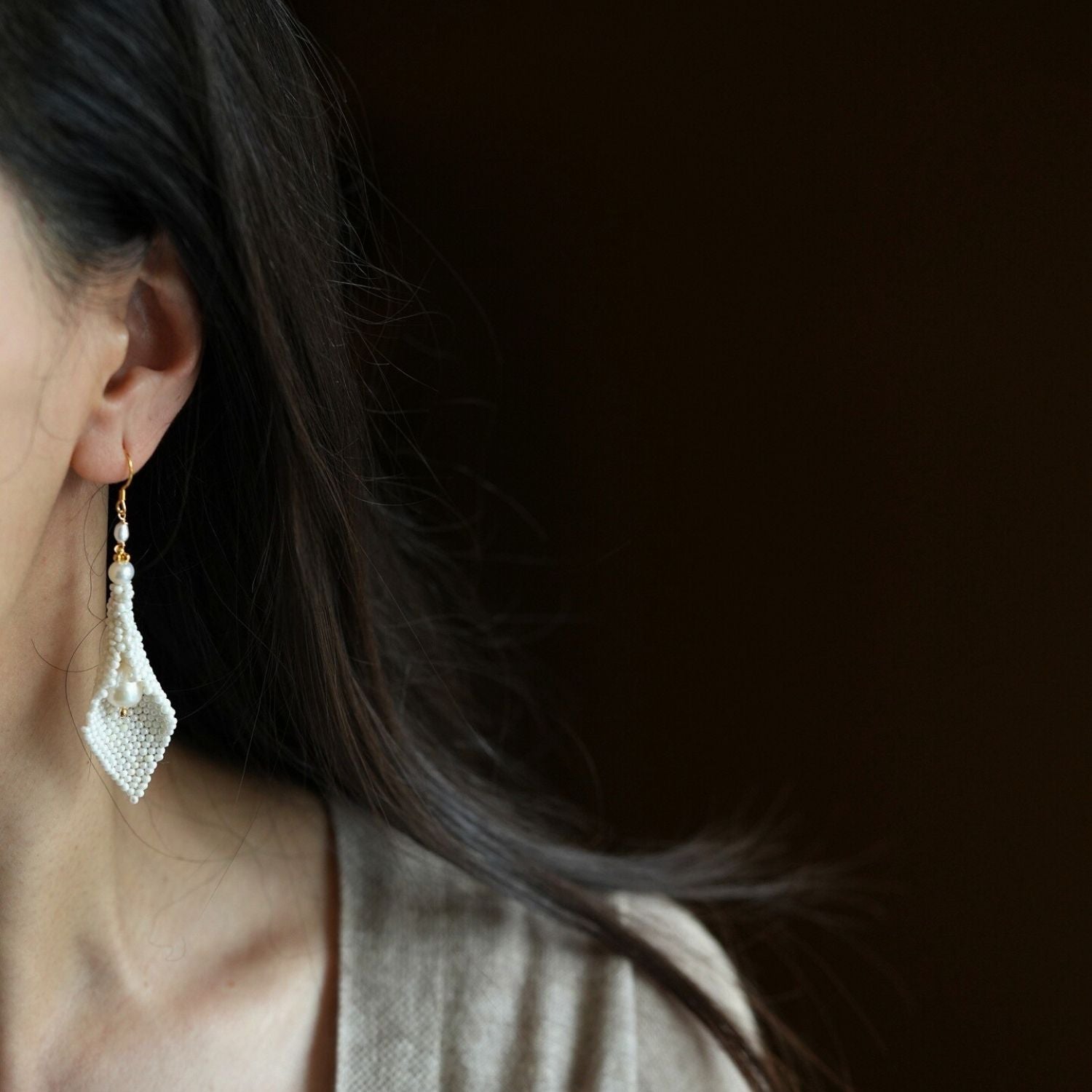 Jinherit Pure Calla beaded calla pearl drop earrings worn by a model, showing the elegant floral drop length, freshwater pearl movement, and bridal-inspired styling.