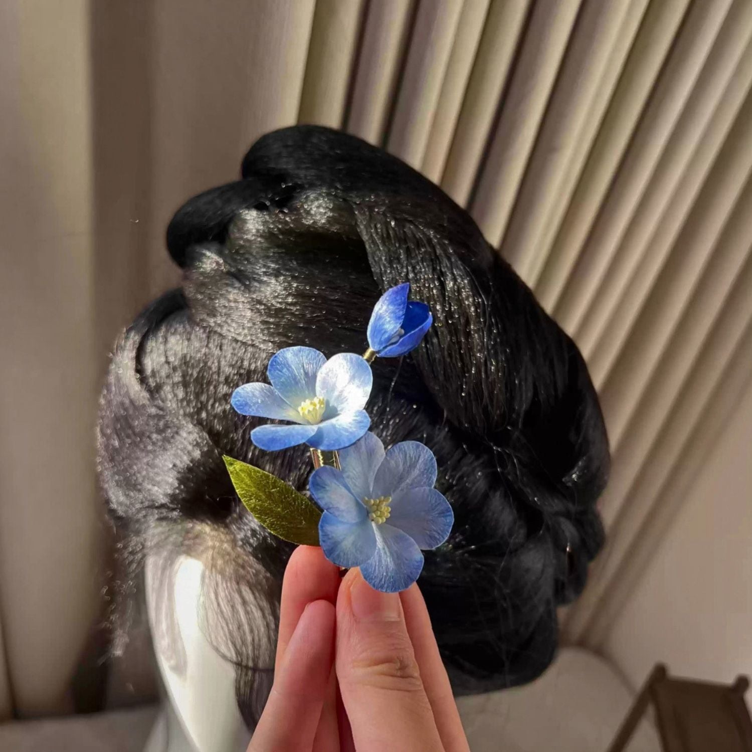 Jinherit Sky Bloom Ronghua silk flower hair clip worn in hair, showing the sky-blue botanical accent, sculptural silk blossoms, and refined side hair styling.