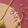 Jinherit Spring Reverie asymmetric hand-painted petal earrings front detail, featuring soft pink petals, freshwater pearl studs, and delicate 14K gold leaf accents.