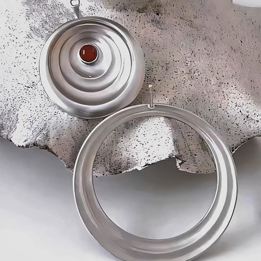 Jinherit Still Ripple matte silver-tone carnelian stud earrings detail view, highlighting the concentric ripple construction, crimson carnelian centre, and convertible design for versatile styling.