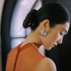 Jinherit Still Ripple matte silver-tone carnelian stud earrings worn by a model, featuring sculptural concentric ripple detailing, a satin-like silver finish, and a bold heritage-inspired statement look.
