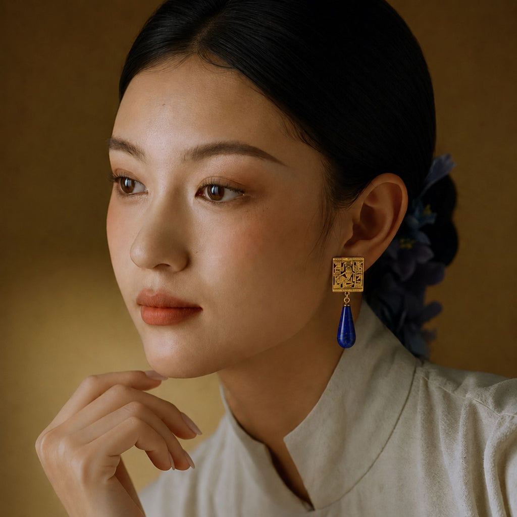 Jinherit Temple of Isis lapis lazuli drop earrings worn by a model, highlighting the gold architectural top, blue gemstone drop, and museum-inspired statement style.