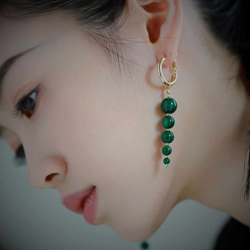 Jinherit Zen Line emerald-green bead drop hoops worn by a model in profile, showing the face-framing drop length, gold-tone hoop structure, and refined minimalist styling.
