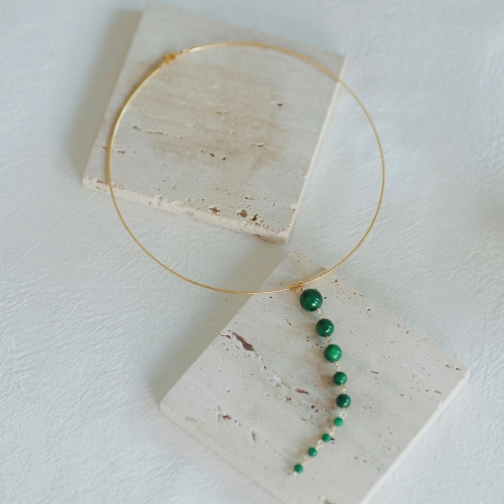 Jinherit Zen Line emerald-green Y-drop lariat necklace detail flat lay, highlighting the slender gold-tone collar, clean Y-drop line, and sculptural green bead arrangement for elegant everyday styling.