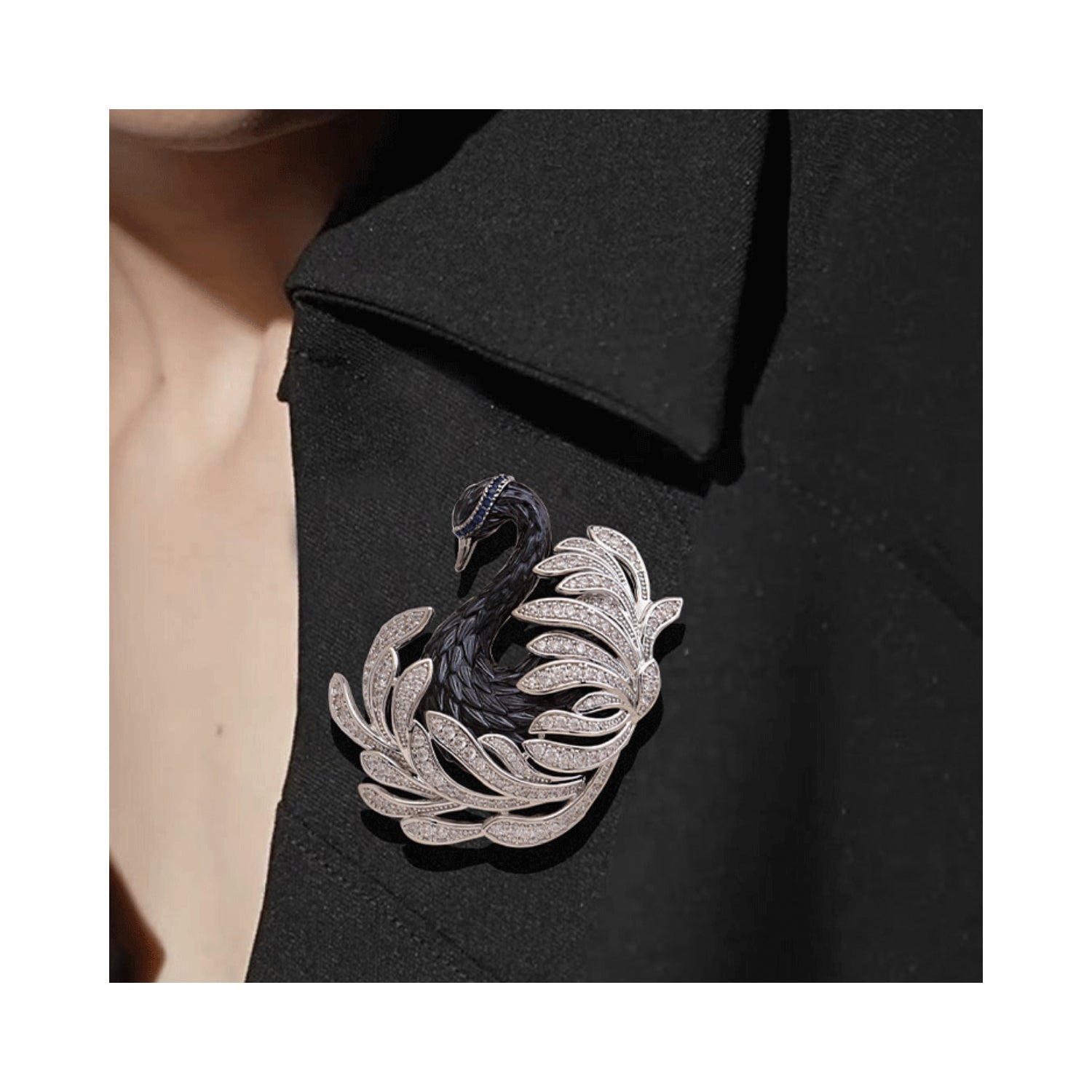 Jinherit Midnight Grace black swan brooch pin worn on a blazer lapel, showing statement styling, silver-tone feather detail, and cool midnight sparkle.