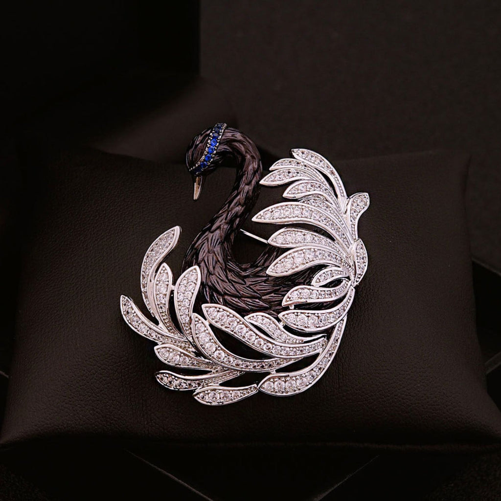 Close-up of black swan crystal brooch with sculptural feather lines, zircon stones, and midnight blue accents.