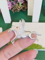 Jinherit Wings of Inspiration Pegasus brooch pin detail video showing sculpted winged horse form, pavé CZ wings, gold and silver tone finishes, and myth-inspired movement.