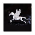 Close-up of Wings of Inspiration Pegasus pavé horse brooch in silver tone on a dark background, featuring the sculpted horse silhouette, pavé wing sparkle, and cool-toned shine.