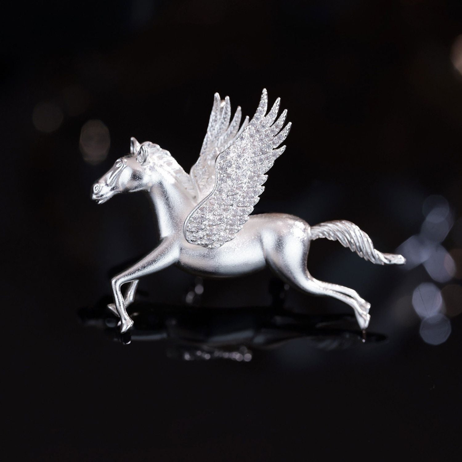 Silver-tone Pegasus brooch with feather-textured wings, CZ sparkle, and polished finish.